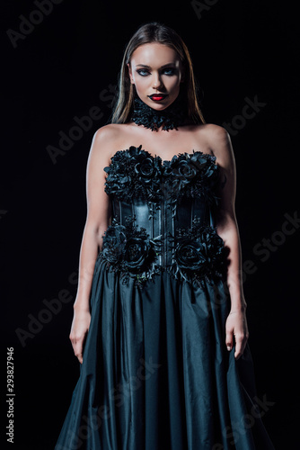 scary vampire girl in black gothic dress isolated on black