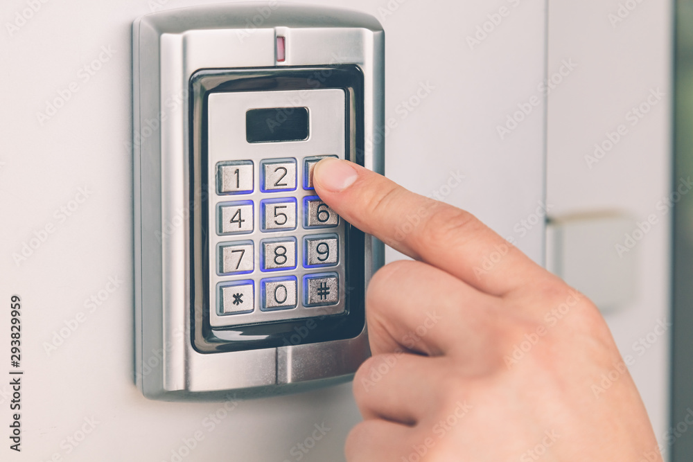 Close up of hand entering security system code Close up of hand entering security system code