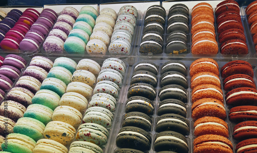 macaroon cakes of different colors on the counter in a candy store or shop