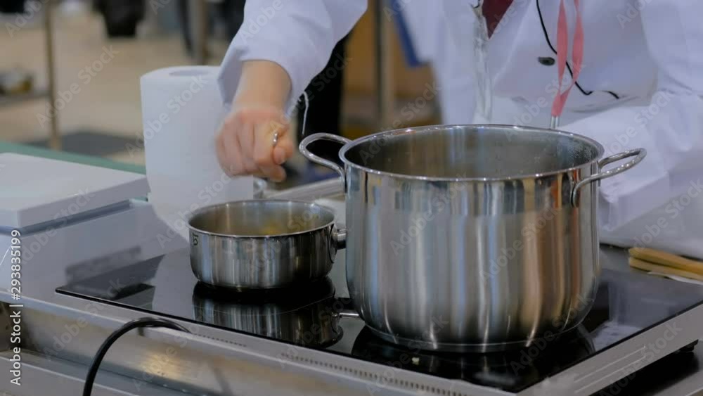 Chef hand stirring rice and millet with spoon in steel pot at cuisine of restaurant. Professional cooking, catering, cookery, gastronomy and healthy food concept Chef hand stirring rice and millet with spoon in steel pot at cuisine of restaurant. Professional cooking, catering, cookery, gastronomy and healthy food concept