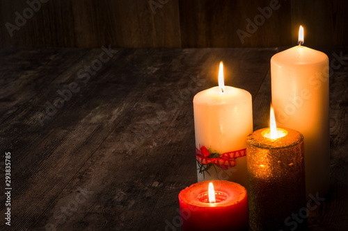 Christmas candles on wooden table. Dim light. Copy space