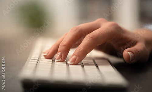 Hand typing on keyboard with office concept