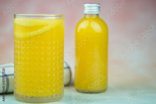 Bottle and glass of orange juice made of fresh oranges