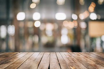 Empty wooden table top with lights bokeh on blur restaurant background.