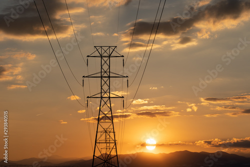 Electric transmission lines against a background of sunset over mountains