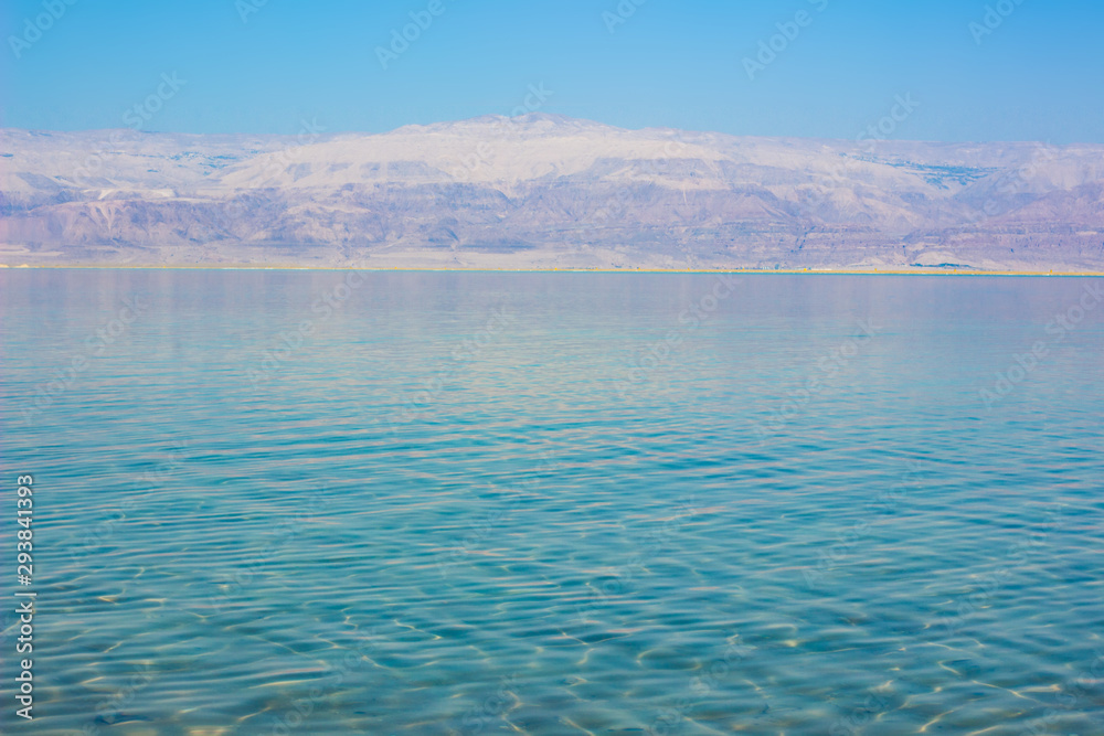 dead sea simple scenery landscape wallpaper poster morning  sun rise view with smooth water surface foreground and mountain horizon background 