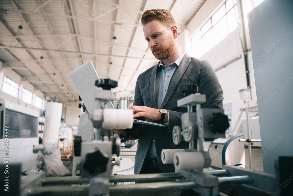 Manager checks machines at the factory. Inspector checks a factory. Manager checks machines at the factory. Inspector checks a factory.