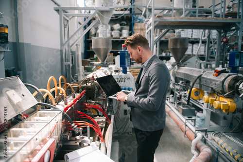 Manager checks machines at the factory. Inspector checks a factory. photo