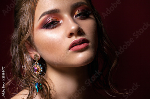 Fototapeta Naklejka Na Ścianę i Meble -  Attractive young model with colorful trendy smoky eyes, bright blue eyes, wet hairdo and fashion earring