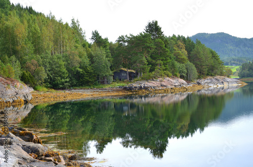 Typical Scandinavian Cabin and a Forest Reflected Over a Lake in Norway