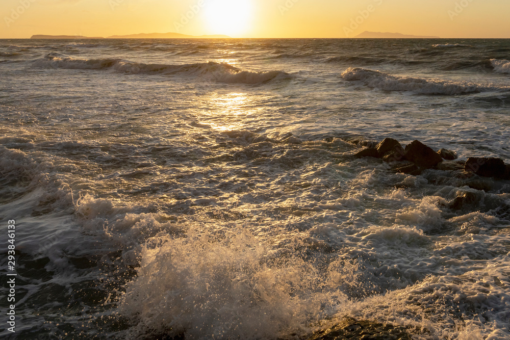 Obraz premium Beauty of the sea - splashing waves lighted by the sunset. Golden hour hues in semi wild unspoiled Logas Beach, Sidari, Corfu, Greece, Europa.