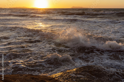 Beauty of the sea - splashing waves lighted by the sunset.