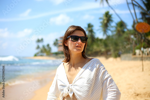 Happy woman traveller enjoying vacation on the beautiful tropical beach in paradise island in Sri Lanka. Freedom concept.