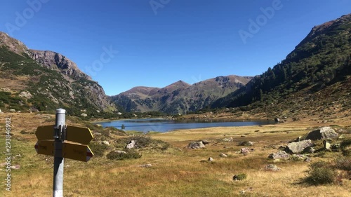 Astonishing static landscape of Murgsee in Switzerland with pointing wooden signs. static panoramic shot photo