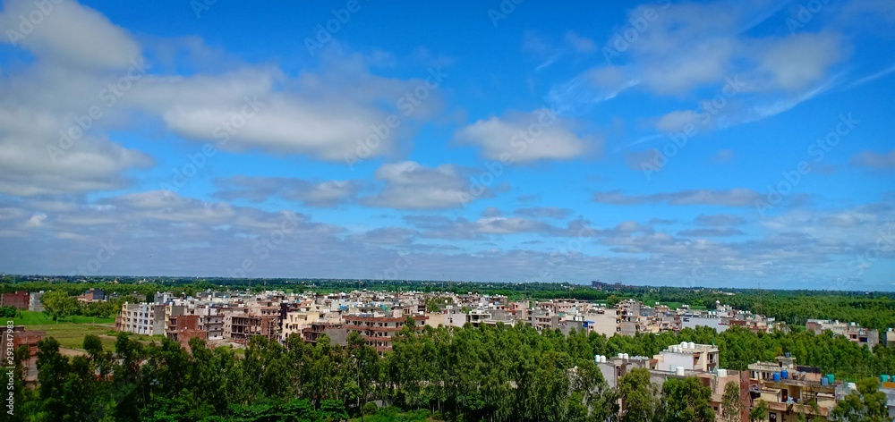 blue sky with white clouds over the city in the afternoon