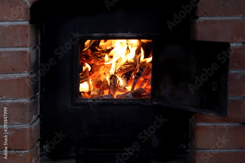 firewood burns in a bright flame in an iron stove