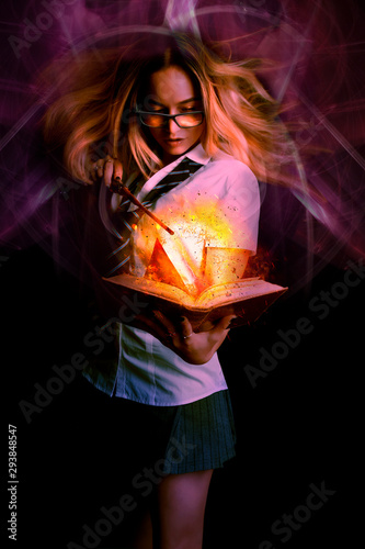 Fotografia Schoolgirl witch casting spells with a magic book - digital composite photograph