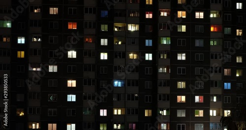 Night panorama time lapse of light in windows of multistory buildings with zoom. life in big city