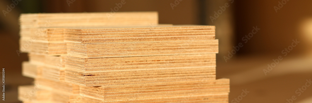Wooden bars lying in a row closeup with manual worker in background. DIY job, inspiration, improvement, fix shop, powersaw bench, joinery startup, workplace idea, career, ruler, industrial education