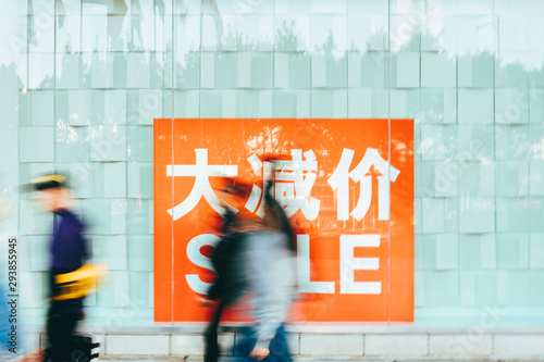 people walking with discount sale sign in China