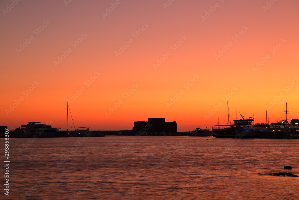 Silhouette lunset landscape with sea, ships in harbor and castle, Papfos, Cyprus