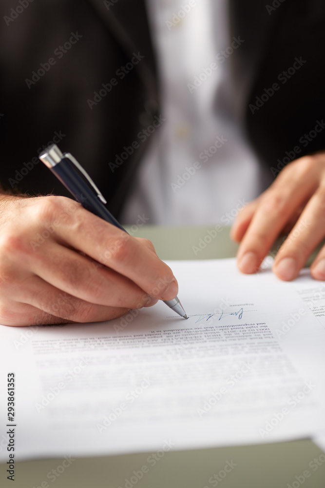 Closeup of man signing paper Closeup of man signing paper