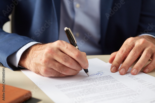 Elegant man subscribing name on paper