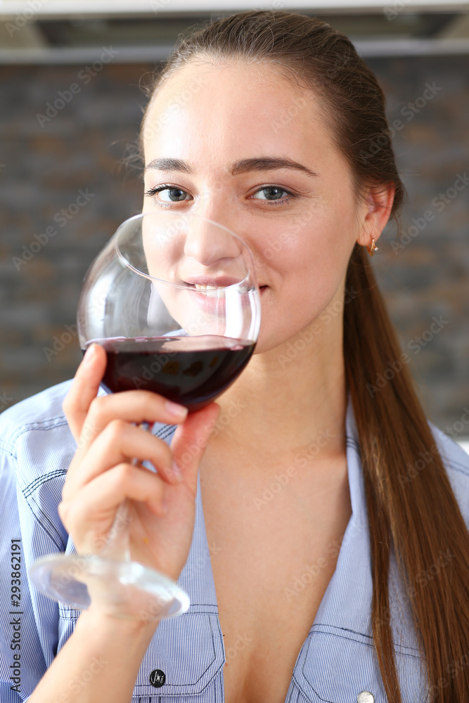 Young beautiful attractive girl drinks wine in the kitchen from a glass at breakfast time, spends her day off with alcohol write a message to a former boyfriend and smiles ex Young beautiful attractive girl drinks wine in the kitchen from a glass at breakfast time, spends her day off with alcohol write a message to a former boyfriend and smiles ex