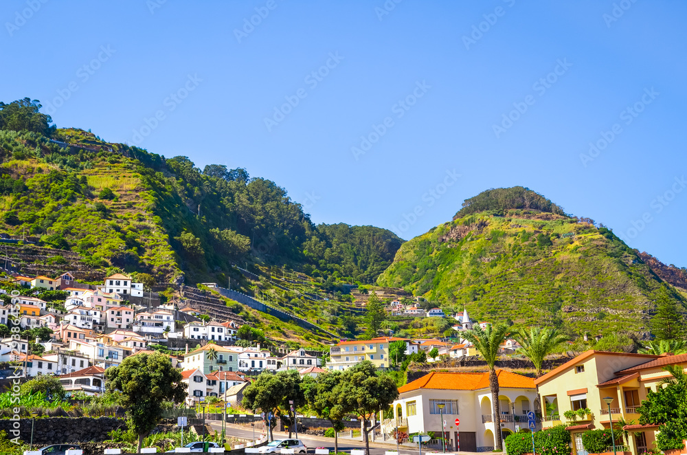 Picturesque village Porto Moniz in Madeira island, Portugal. Beautiful northern coast of the island. Small portuguese city surrounded by green hills. Amazing landscape. Tourist destination Picturesque village Porto Moniz in Madeira island, Portugal. Beautiful northern coast of the island. Small portuguese city surrounded by green hills. Amazing landscape. Tourist destination