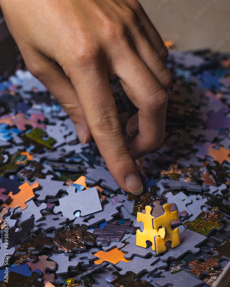 Two yellow puzzles looking at hand reaching for other puzzles. The concept of taking part in recruitment. Two yellow puzzles looking at hand reaching for other puzzles. The concept of taking part in recruitment.