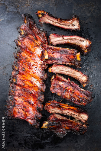 Barbecue pork spare ribs St Louis cut with hot honey chili marinade as top view on an old rustic metal board with copy space