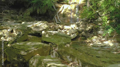 Slow Drone Flying Toward Forest Waterfall Over Stones And Stream. Aerial POV . Gelendzhik, Kuago river, Russia photo