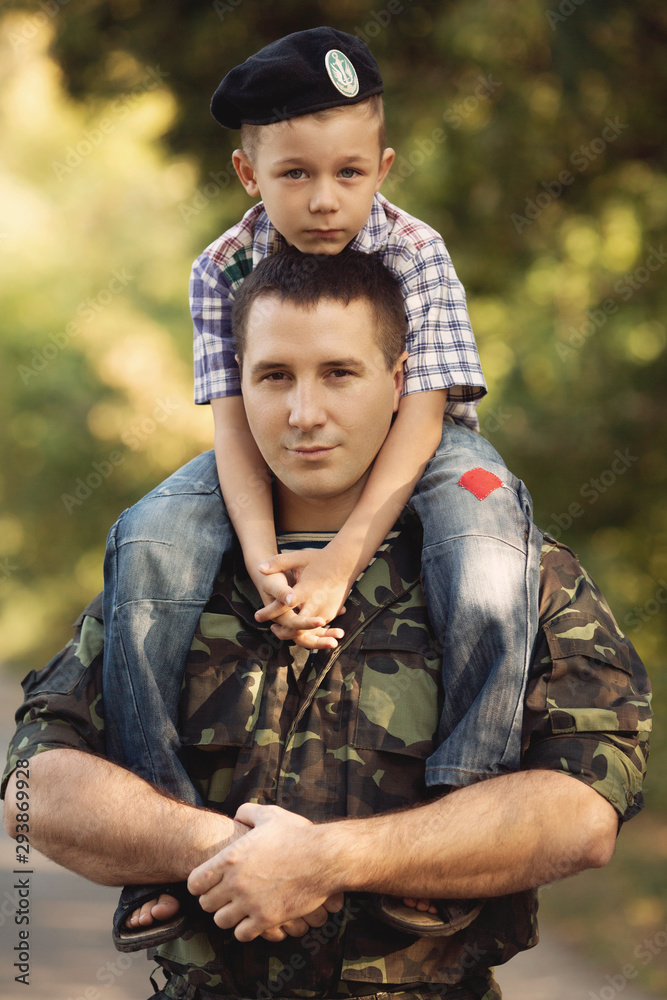 Boy and soldier in a military uniform say goodbye before a separation