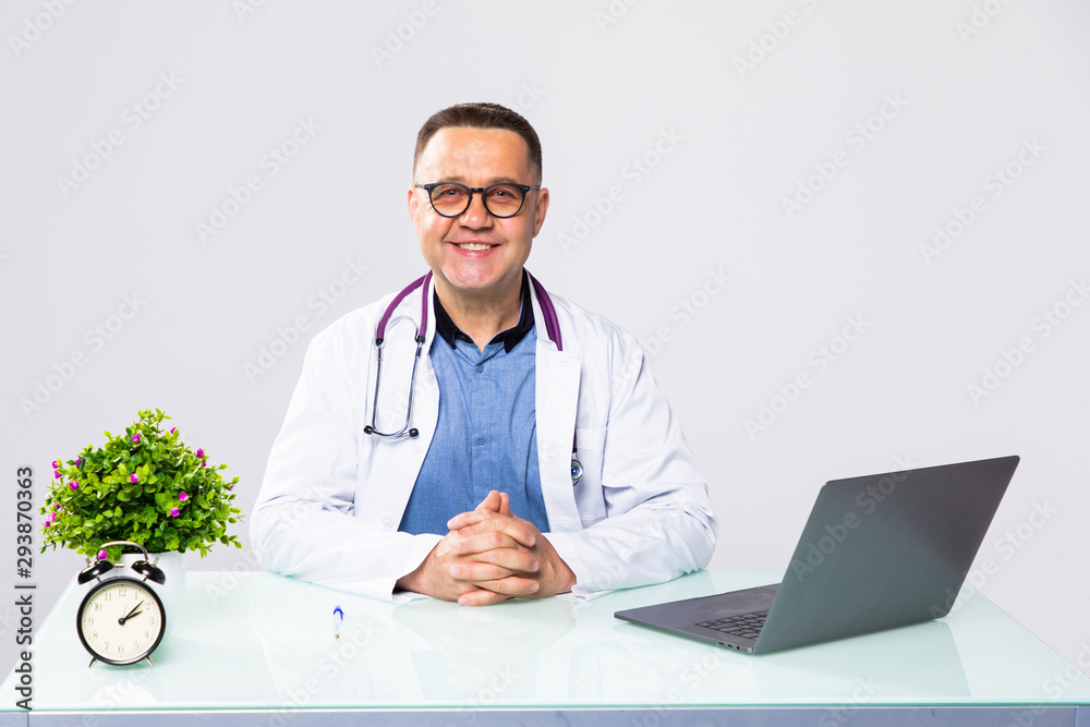 Portrait of man doctor holding document at table in clinic Portrait of man doctor holding document at table in clinic