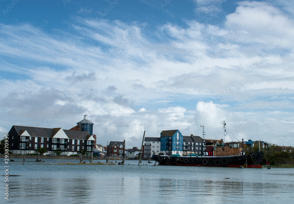 River Arun Littlehampton a scenic view with calm water at high tide and dramatic cumulus clouds.