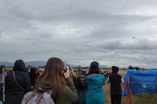 A young brunette woman uses a pro DSLR to capture the aerial display at the Abbotsford International Airshow.