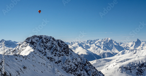 A hot air baloon over the Swiss Alps in winter time