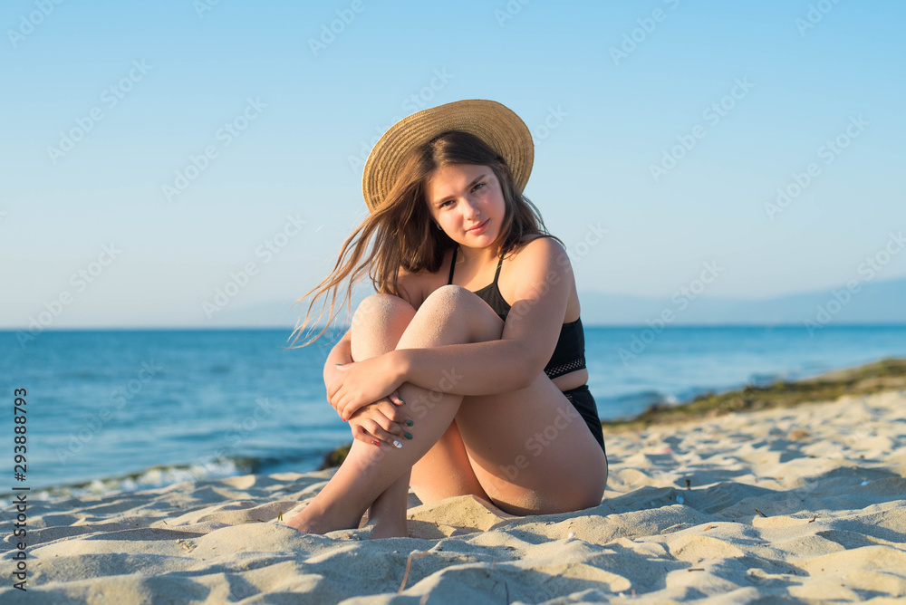 Cheerful plus size teenage girl wearing hat enjoying the beach. smiling, happy, positive emotion, summer style. Cheerful plus size teenage girl wearing hat enjoying the beach. smiling, happy, positive emotion, summer style.