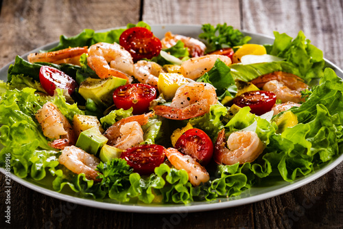 Salad with shrimps on wooden background photo