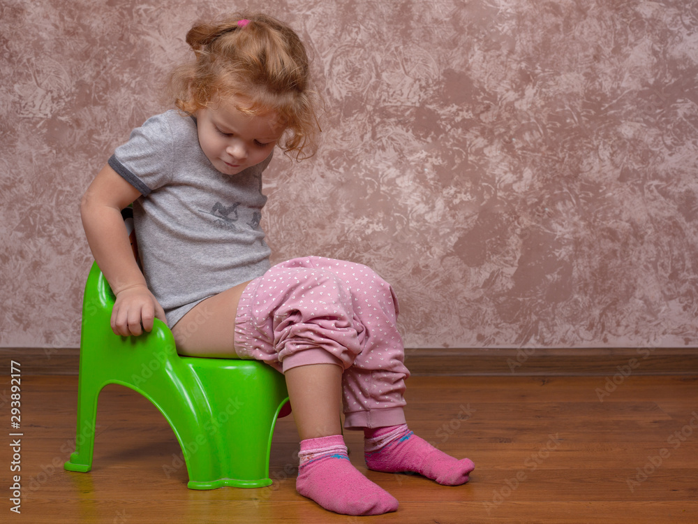 little girl sitting on the potty,the child learns to go to the toilet on  potty Stock Photo