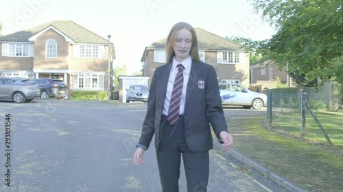 Senior school girl walking to school listening to music and dancing themes of carefree dancing fun education