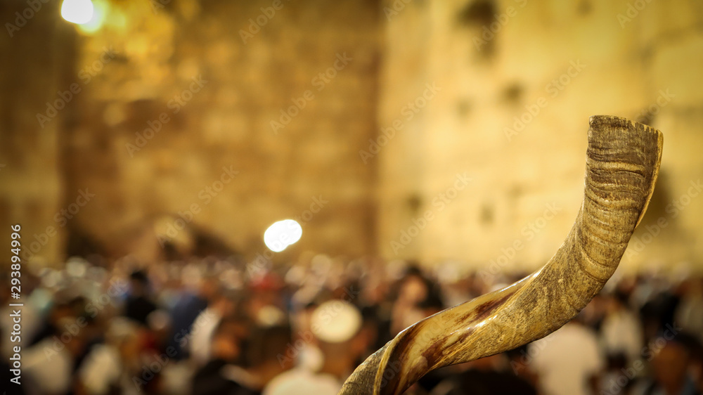 Obraz premium Shofar and in the background religious people pray at the Western Wall in the Holy City of Jerusalem in Israel