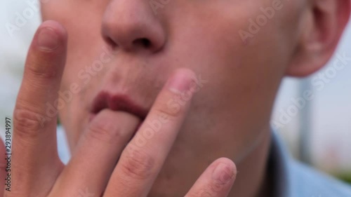 Satisfied man licks fingers after eating, close up photo