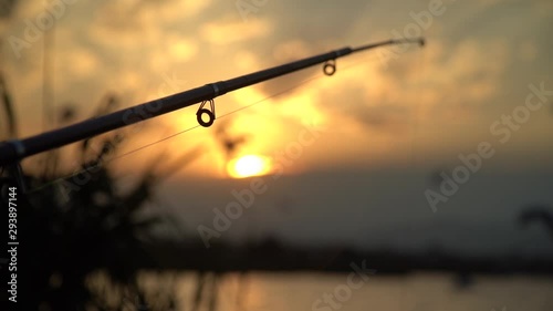 Man fishing on the lake at sunset. Beautiful sunset on the sea - Slow Motion. Birds slowly fly against beautiful sunset. Slowmotion