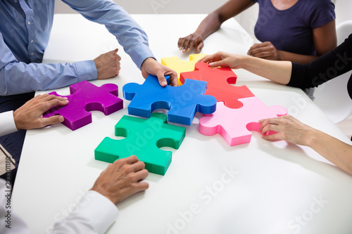 Businesspeople Building Colorful Jig Saw Puzzles Together