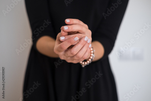 Woman's hands with white nail polish