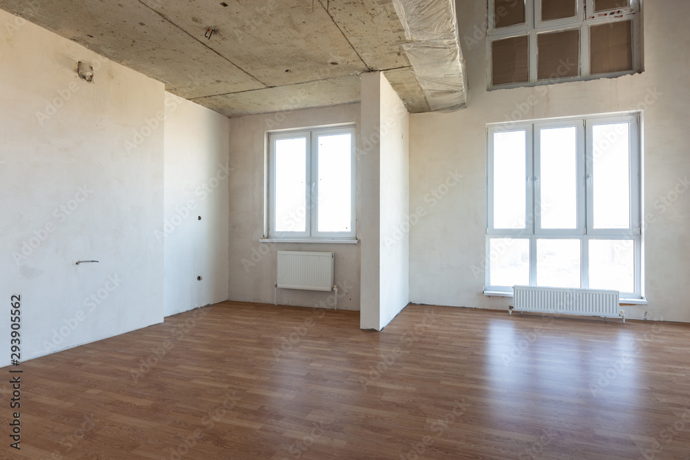 The interior of the spacious room without repair, with laid laminate The interior of the spacious room without repair, with laid laminate