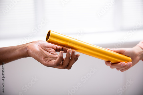 Passing Golden Relay Baton To Other Person