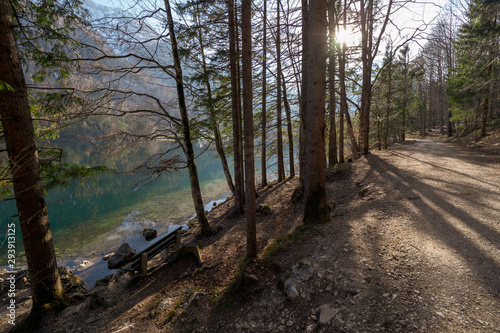 Empty wooden bench at the shore of the Vorderer Langbathsee near Ebensee, OÖ, Austria, with the great landscape reflecting on the crystal clear water photo