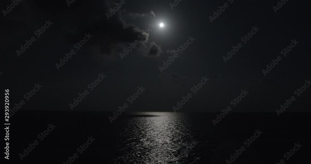 Full moon illuminates the ocean water while sailing